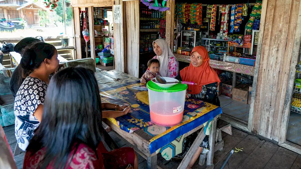 "Indonesische Frau in ihrem von BOS-Mikrokrediten unterstützten Kiosk" – Zeigt eine lokale Unternehmerin, die durch BOS Schweiz-Mikrokredite ihren Kiosk betreibt und so zur wirtschaftlichen Entwicklung und Gemeinschaftsstärkung in Indonesien beiträgt.
